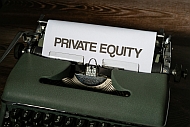 Auf dem Bild ist eine alte Schreibmaschine abgebildet. Auf dem eingespannten Papier steht privat equity.
