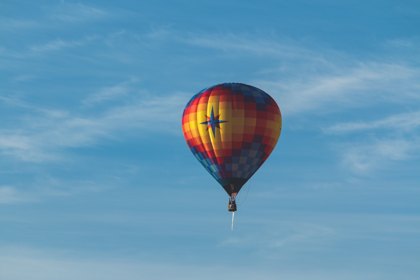 Ein Heißluftballon schebt im blauen Himmel.